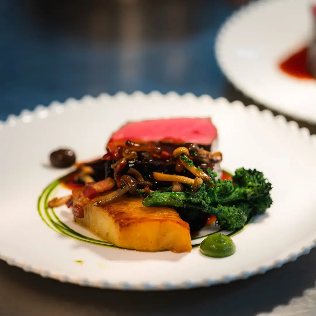 A main course of meat with greens and sauce