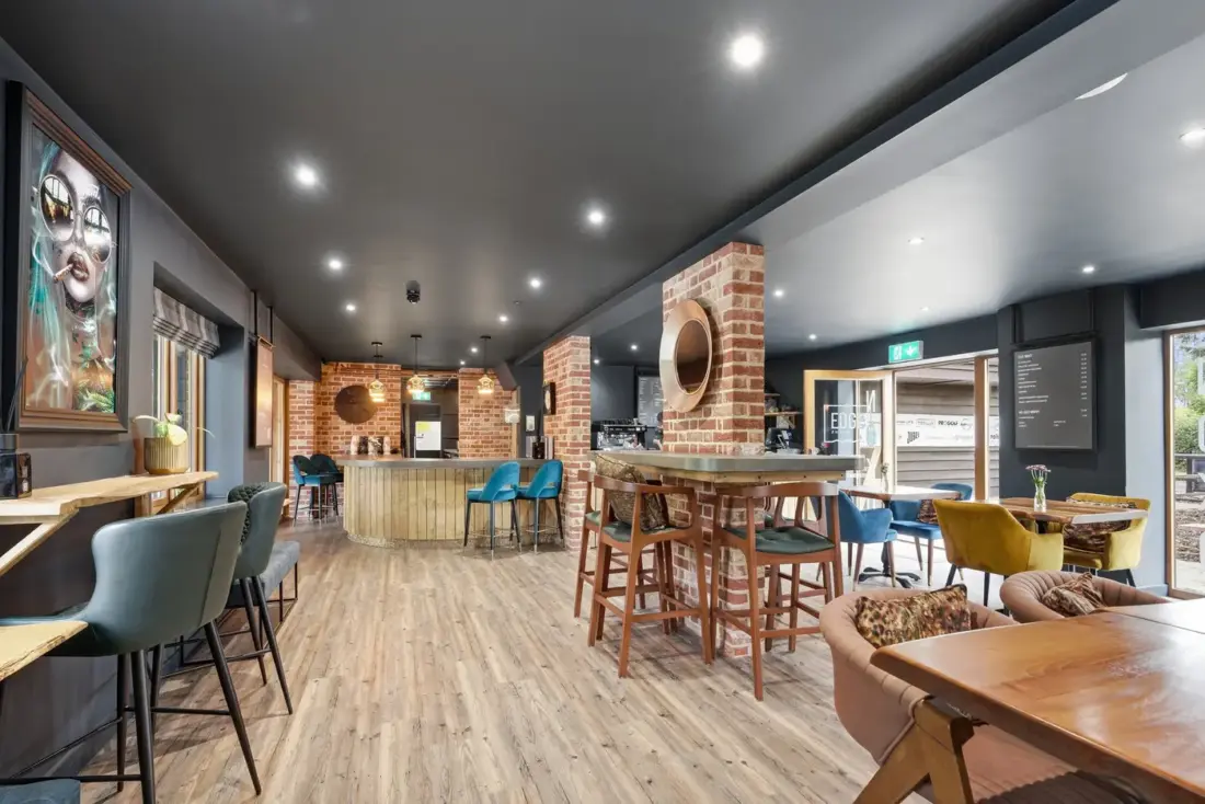 The cafe at Edge//Noko with timber floor, brick pillars and pendant lights